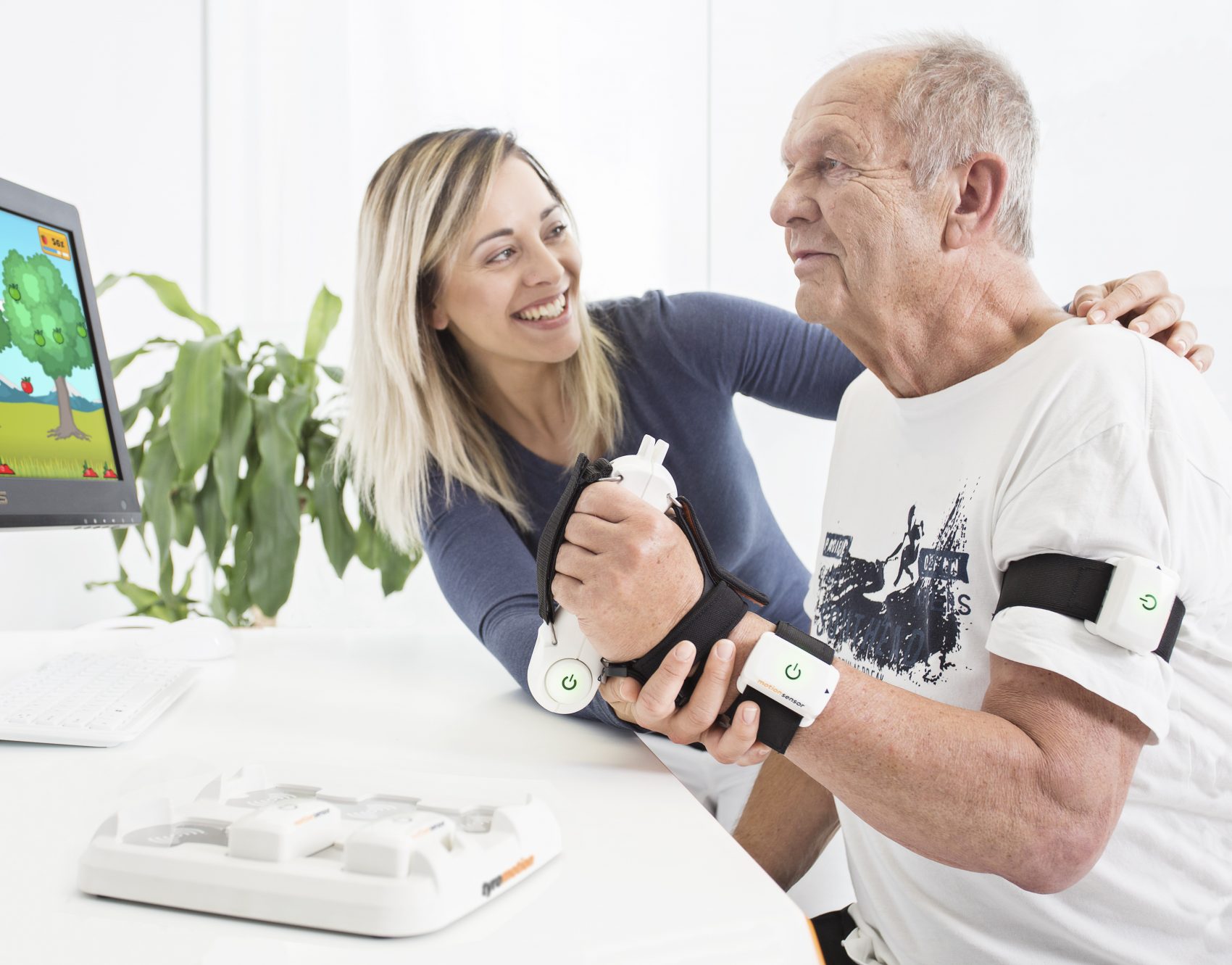 PABLO in Therapieanwendung mit älterem Patienten, hält Sensor in der Hand