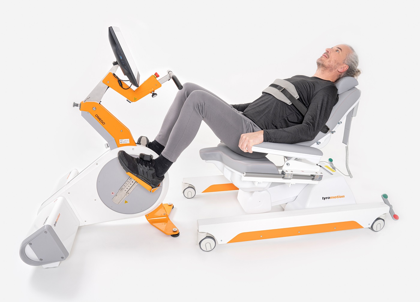 Man with grey hair in a lying position on a robotic gait training device