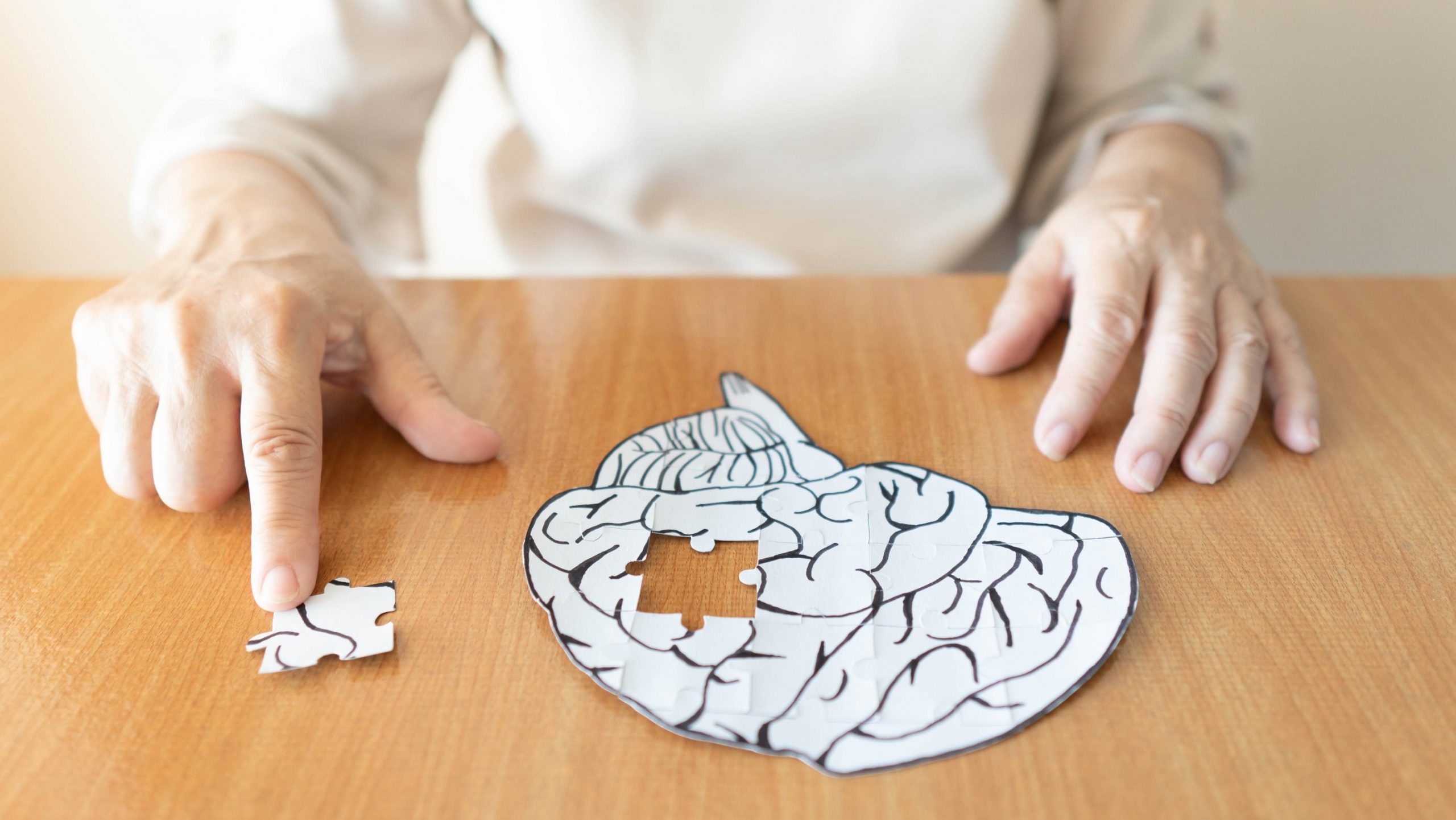 Woman doing a jigsaw puzzle of a brain