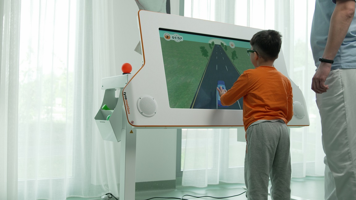 Boy playing a car game on MYRO – a robotic therapy device