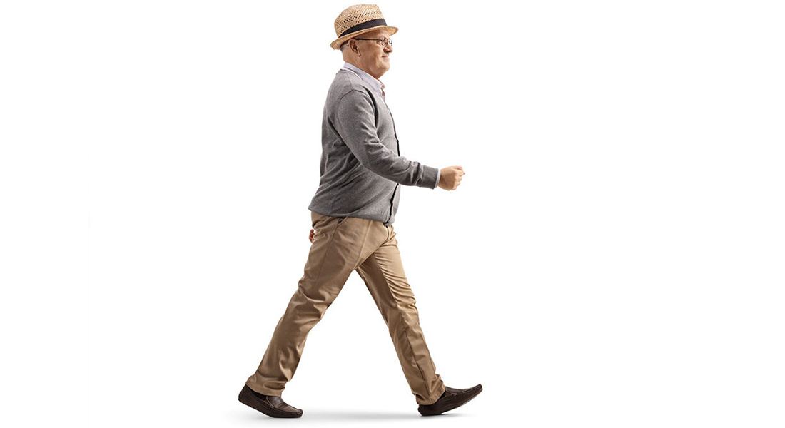 Elderly gentleman with hat doing gait training, putting his left foot forward.