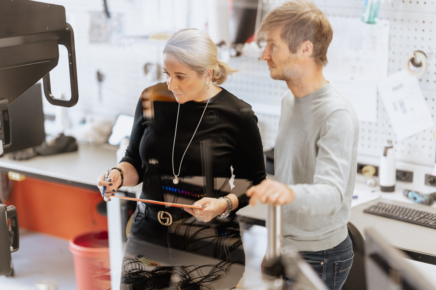 Woman and a men looking at a big medical devices and thinking about innovation.